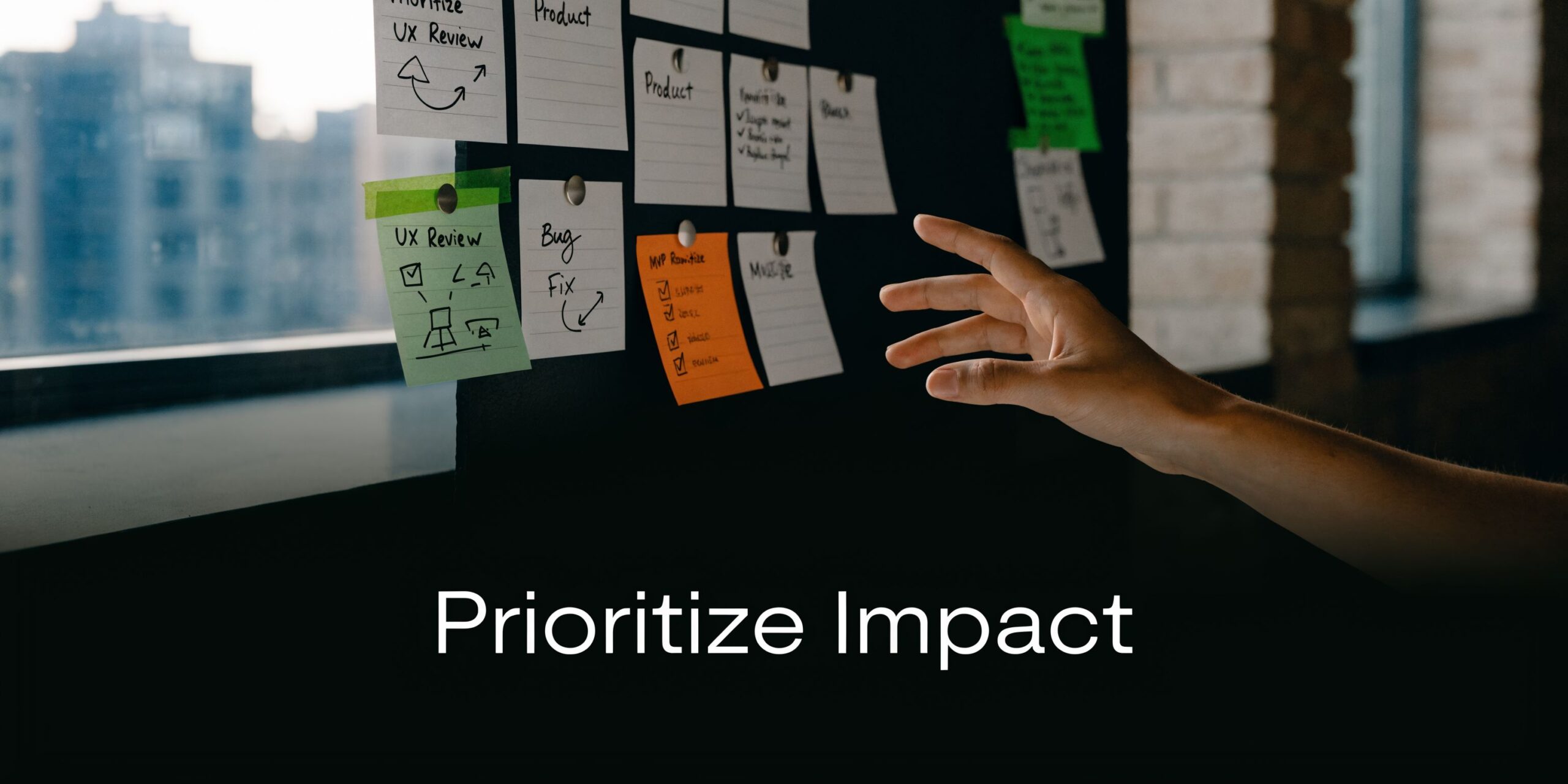 A person pointing to sticky notes on a board, illustrating the concept of prioritizing impact in business.